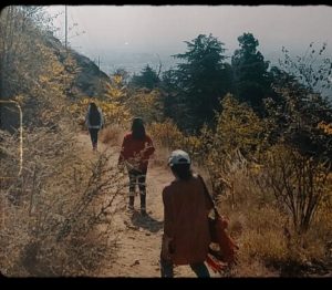 Three women wind through a semi-arid trail in the mountains of Srinagar, Kashmir. 